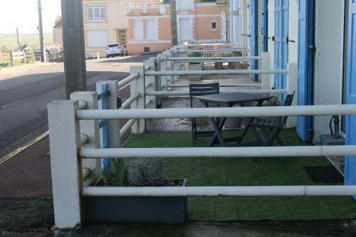 a fence with tables and chairs outside of a building at escapade en mer in Ault