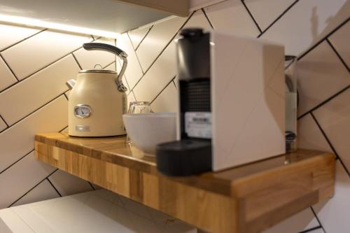 a blender on a wooden shelf in a kitchen at Sea Suites -סוויטה מהממת עם ג'קוזי ליד הים והטיילת באשקלון in Ashqelon