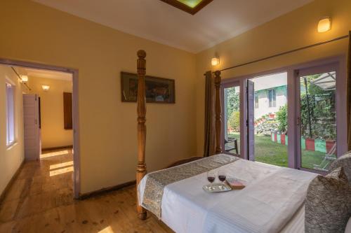 a bedroom with a bed and a table with drinks on it at Binsar Eco Resort, Binsar - Uttarakhand in Hawālbāgh
