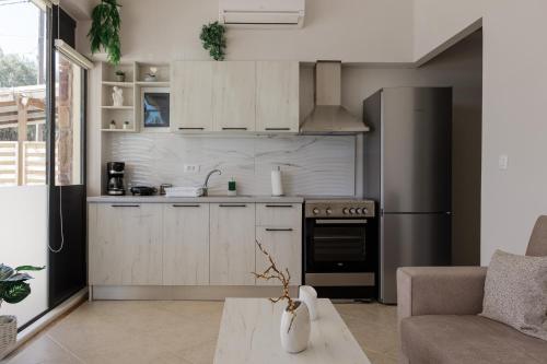 a kitchen with white cabinets and a stainless steel refrigerator at Stella's Apartment Karfas in Karfas