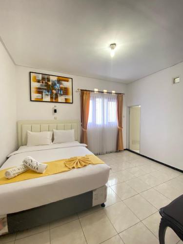 a bedroom with a large bed with a yellow blanket at In Villa Garden Resort in Batu