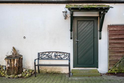 a bench in front of a house with a door at Harmonie Hof in Oyten