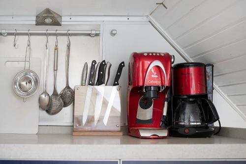 a kitchen counter with a red coffee maker and utensils at Harmonie Hof in Oyten