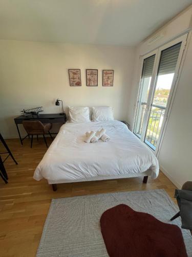 a bedroom with a bed with two stuffed animals on it at calme en plein centre in Drancy