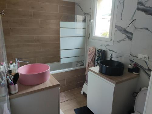 La salle de bains est pourvue d'une baignoire rose et d'un lavabo. dans l'établissement Villa Toulon Ouest - House west Toulon, à Toulon