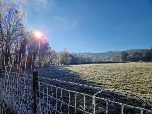 Une clôture dans un champ avec le soleil derrière. dans l'établissement La maisonnette, à Le Nayrac