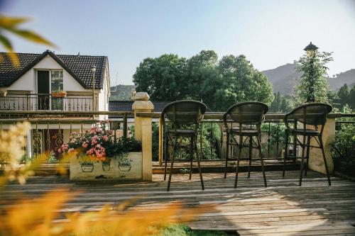 two chairs on the deck of a house at 杭州茶香丽舍旅居民宿 in Hangzhou