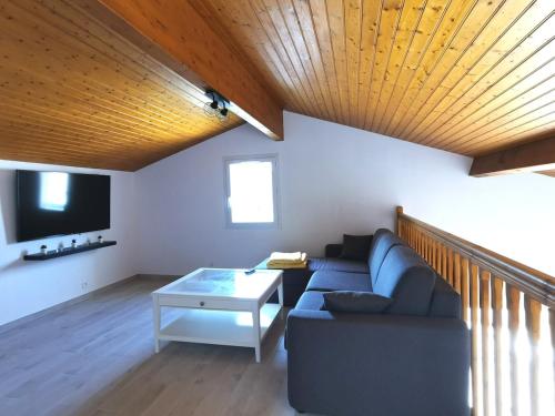 a living room with a couch and a tv at Vaux sur Mer - Royan Villa très proche de l'océan in Vaux-sur-Mer