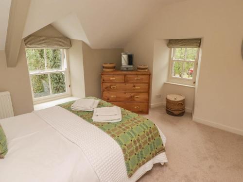 Un dormitorio con una cama y una cómoda y dos ventanas. en Sea View, en Newport