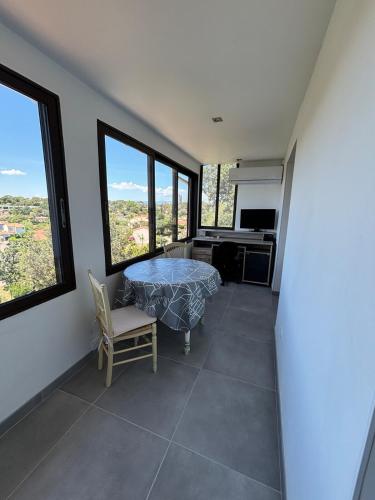 Cette chambre dispose d'une table, d'un bureau et de fenêtres. dans l'établissement Comfort & private garden T2 - air conditioning - Wi-Fi - parking, à Saint-Raphaël