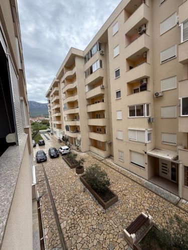 un immeuble d'appartements avec des voitures garées dans une cour dans l'établissement Stan 60m2, à Bar