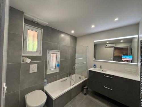une salle de bain avec toilettes, baignoire et lavabo dans l'établissement Comfort & private garden T2 - air conditioning - Wi-Fi - parking, à Saint-Raphaël