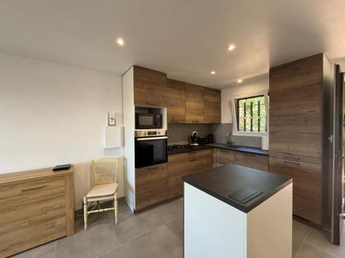une cuisine avec des armoires en bois et un comptoir dans l'établissement Comfort & private garden T2 - air conditioning - Wi-Fi - parking, à Saint-Raphaël