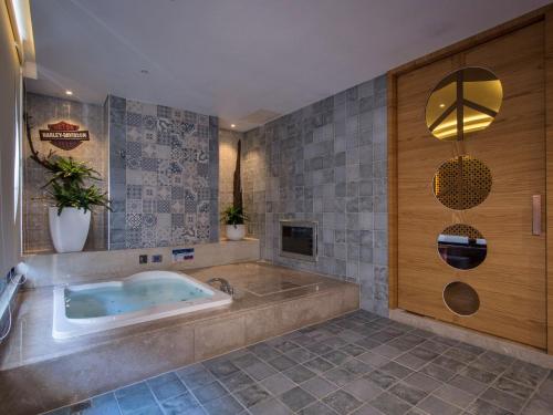 a large bathroom with a tub and a sink at U-Her Hotel in Taichung