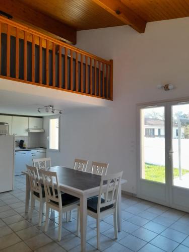 une salle à manger avec une table et des chaises dans une cuisine dans l'établissement Vaux sur Mer - Royan Villa très proche de l'océan, à Vaux-sur-Mer