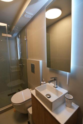a bathroom with a sink and a toilet and a mirror at Liora Retreat in Kavála
