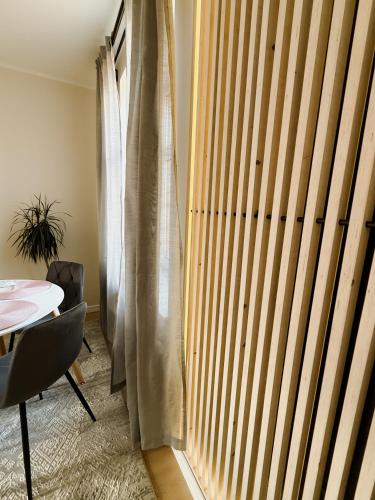 a room with a wooden door and a table and a window at Cēsis Home&Heart Apartments in Cēsis
