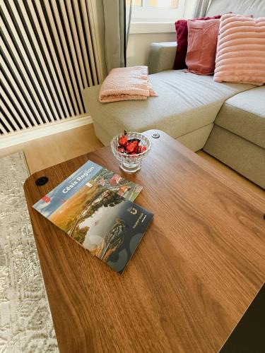 a coffee table in a living room with a book on it at Cēsis Home&Heart Apartments in Cēsis