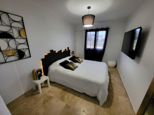 une chambre avec un grand lit blanc et une fenêtre dans l'établissement Gîte de charme L'Escale Des Sens sauna et jacuzzi privé sud Ardéche, à Bessas