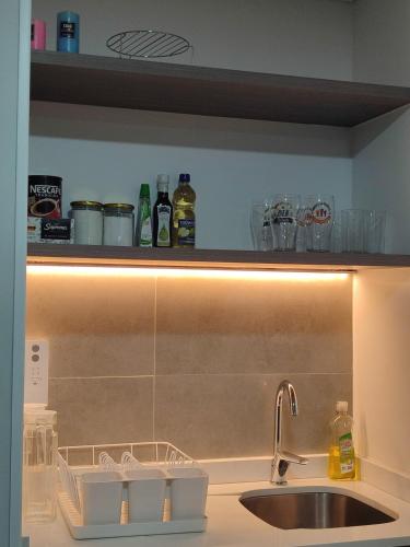 a kitchen with a sink and a counter with a light at Comodidad y tranquilidad en Ñuñoa in Santiago