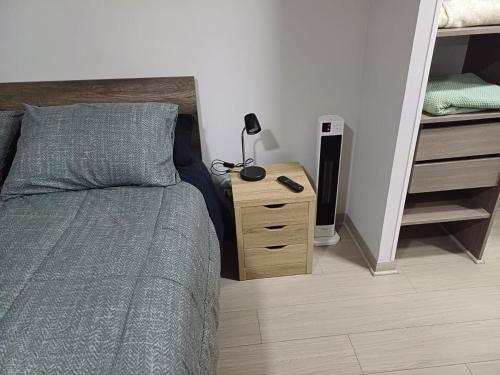 a bedroom with a bed and a night stand with a lamp at Comodidad y tranquilidad en Ñuñoa in Santiago