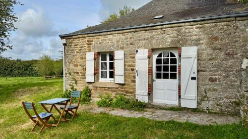 a stone house with two chairs and a table at Gîte de couple Cosy avec vue sur Château Trémohar - Golfe du Morbihan, 20 min de Vannes in Berric