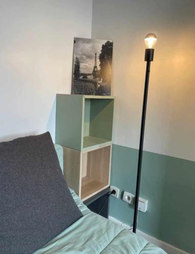 - une chambre avec un lit, une lampe et une photo dans l'établissement Charming 2 rooms near Basilica of Saint-Denis, à Saint-Denis