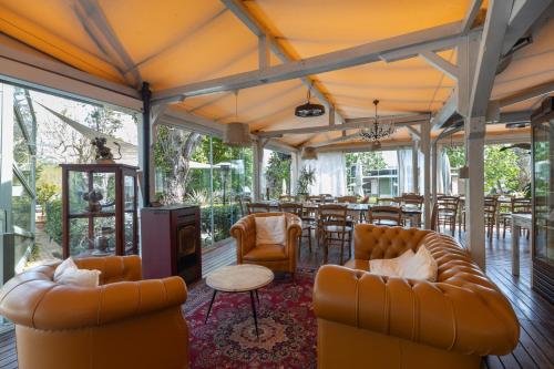 a restaurant with couches and a table and chairs at La Valle Dei Caprioli Village Bungalow Park - Freelandia Azienda Agricola in Montescudo