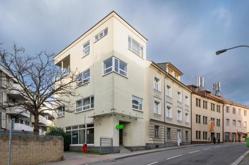 un grande edificio bianco su una strada cittadina di Veleslavin Apartments a Praga
