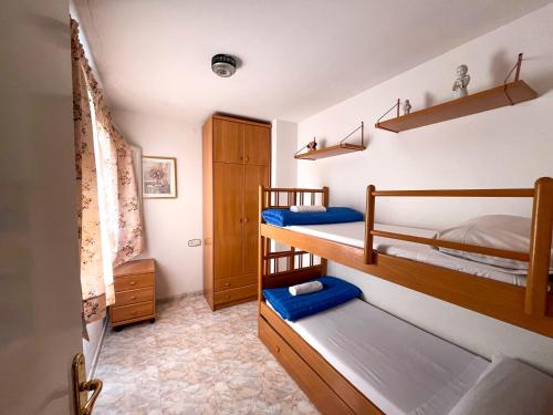a room with two bunk beds and blue towels at Apartamentos Mar Bella Segur de Calafell 3000 in Segur de Calafell