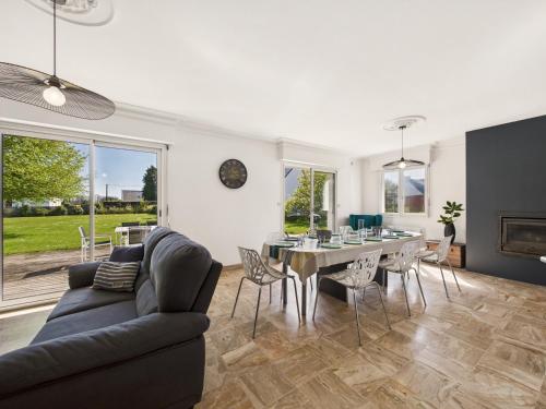 un salon avec un canapé, une table et des chaises dans l'établissement Maison moderne pour 12, grand jardin, terrasse, à Concarneau