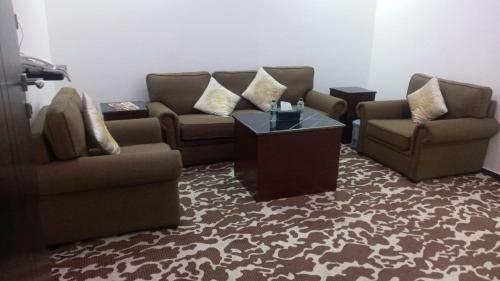 a living room with couches and a coffee table at حي بلاس للأجنحة الفندقية in Najran