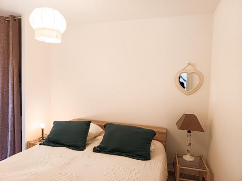 une chambre avec un lit avec deux oreillers verts dans l'établissement Location maison LORGUES 