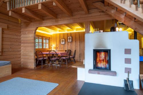 a dining room with a fireplace in a log cabin at Schwarzwald Blockhaus - Sauna - Kamin - mit Bettwäsche und Handtücher in Schenkenzell