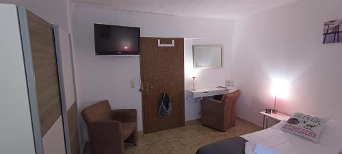 a hotel room with a bed and a desk and a sink at Pension Bergblick in Ruhpolding