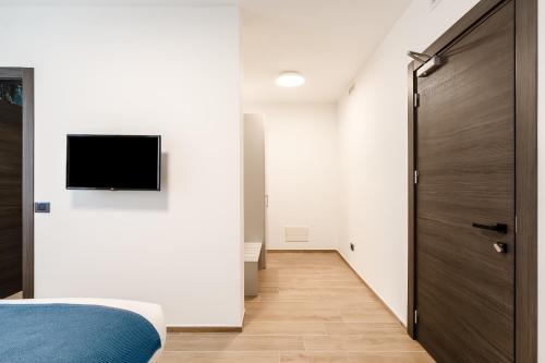 a bedroom with a bed and a television on a wall at Villa Grace Milan in Milan