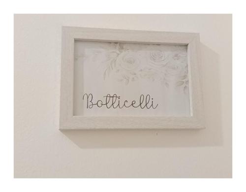 a picture frame with a picture of flowers on a wall at La Principessa Nera B&B in Ostra