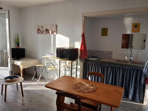 un salon avec une table et une cuisine dans l'établissement logement à la campagne, à Soulaines-sur-Aubance