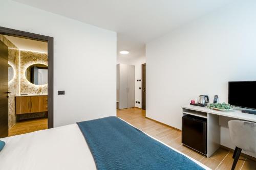 a bedroom with a bed and a desk and a television at Villa Grace Milan in Milan