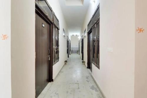 a hallway with white walls and a long corridor with doors at Hotel The Royal Palace in Murādnagar