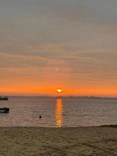 a sunset on the beach with the sun setting at Relax place & restaurant in Zegrze Południowe