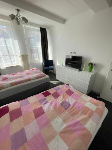 a bedroom with two beds and a flat screen tv at Aydogan Vermietung in Stade