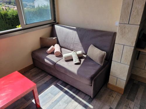 - un canapé avec des oreillers dans l'établissement Charmant 2 pièces vue mer et château et parking, à Villeneuve-Loubet