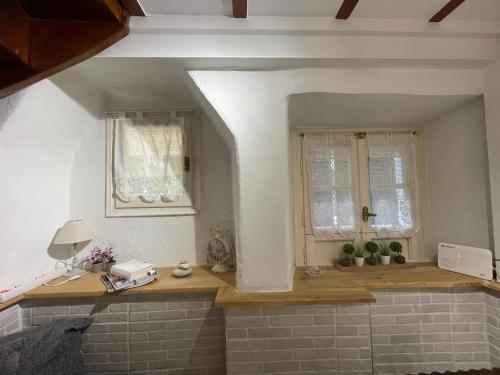 a kitchen with two windows and a wooden counter at Grandma’s old town house in Corfu Town