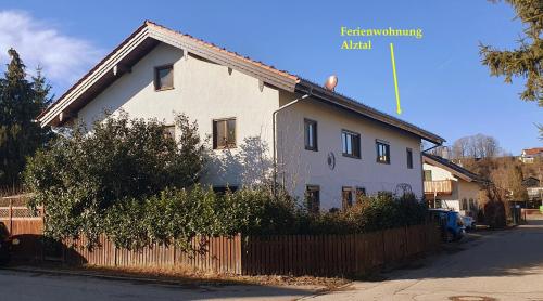 a white house with a fence in front of it at Ferienwohnung Alztal - mit Wallbox in Altenmarkt an der Alz