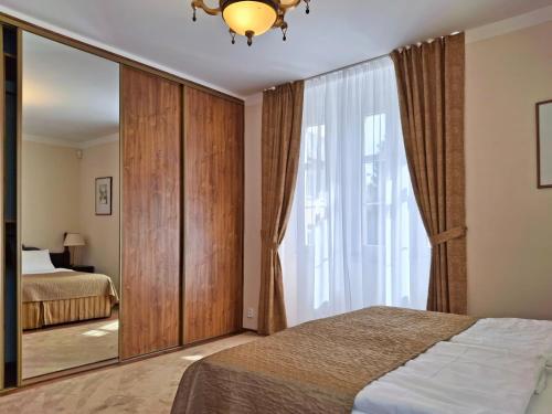 a bedroom with a mirror and a bed at Villa Patriot Apartmány in Mariánské Lázně