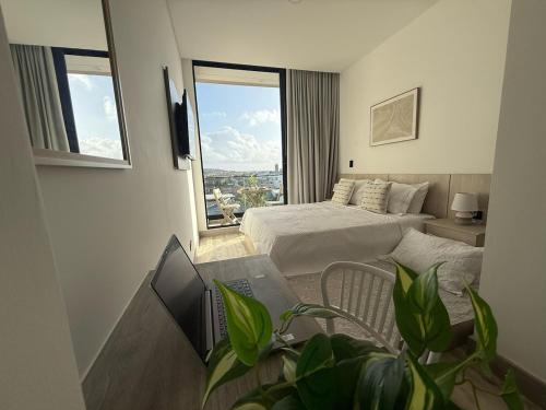 a hotel room with a bed and a laptop on a desk at Almare Apartamentos nuevos in Gustavo Rojas Pinilla International