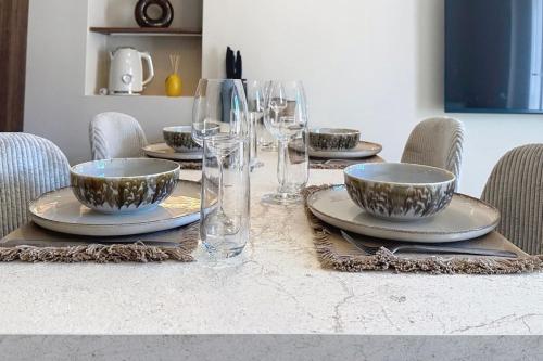 une table avec des assiettes et des verres à vin dessus dans l'établissement Le Montfleury 2 pièces à 300m de la plage, à Cannes