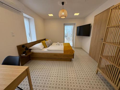 a bedroom with a bed and a television and a table at BARRIQUE Farmhouse in Csopak