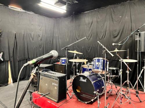 a stage with a drum set and a microphone at アグリランドえい in Orio